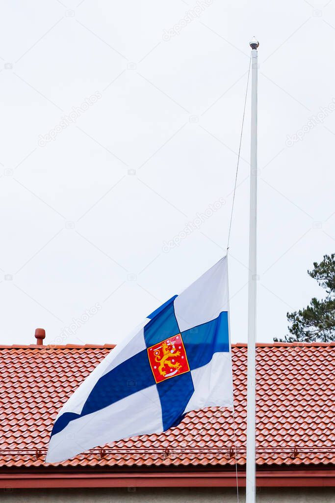Finnish flag lowered to half mast on the occasion of mourning at cloudy autumn day