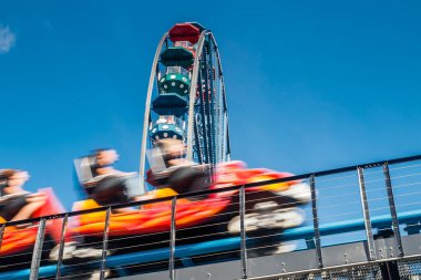 Dönme dolap ve lunaparkta hız treni hareket halinde.
