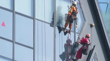 November 14th 2025 - Yangon, Myanmar: Window cleaners strapped into harnesses on a high-rise Glass office building.