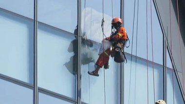 November 14th 2025 - Yangon, Myanmar: Window cleaners strapped into harnesses on a high-rise Glass office building.