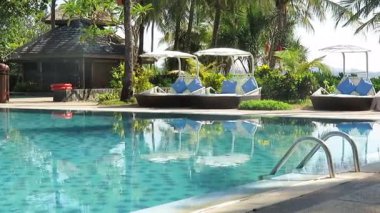 Ngwesaung, Myanmar 'daki Aureum Palace Oteli' nde yüzme havuzunun durgun, turkuaz sularında palmiye ağaçları var.