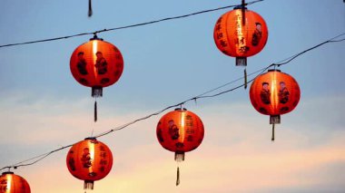 Geleneksel Çin fenerlerinin dingin bir günbatımı gökyüzüne asılmış canlı kültürel güzelliğini deneyimlemek, bayram kutlamaları ve kültürel mirası çağrıştırıyor..