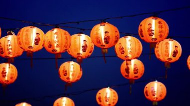 Çok güzel aydınlatılmış Çin fenerleri koyu mavi bir gökyüzüne asılıp kültürel etkinlikler ve kutlamalar için mükemmel şenlikli ve canlı bir atmosfer yaratıyorlar..