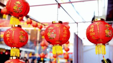 Altın aksanlı ve çiçekli kırmızı Çin fenerleri hareketli bir pazarda asılı, neşeli ve neşeli bir atmosferi çağrıştırıyor..