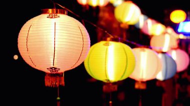 Güzel ışıklandırılmış kağıt fenerler canlı renkler ve parlayan ışıklarla şenlikli bir gece atmosferi yaratıyor..