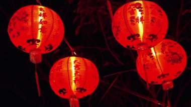 Gece parlayan canlı kırmızı Çin fenerlerinin sihrini deneyimlemek kültürel bir kutlama ve şenlik havası uyandırır..