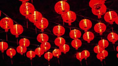 Bu canlı kırmızı Çin fenerlerinin arka planda asılı olduğu, kültürel kutlamalar ve dekorasyonlar için mükemmel bir şenlik ortamı yaratmak.