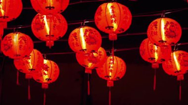 Güzel aydınlatılmış kırmızı Çin fenerleri şenlikli bir atmosfer yaratıyor.