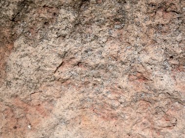 Bu resim, eşsiz dokularını ve canlı renklerini vurgulayan sert bir kaya yüzeyinin yakın çekimini gösterir.