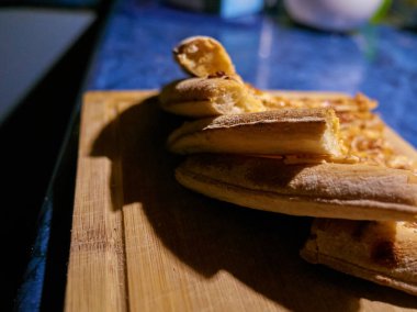 Karamsar ışıklandırma altında kesilmiş pizza dilimleri, dramatik gölgeler eritilmiş peynir ve kalın