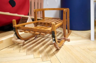 Parke zemindeki ahşap kızak nostaljik sıcaklığı çağrıştırıyor. Tatil için butik sergi malzemesi olarak sahnelenen klasik oyuncak.