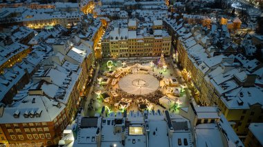 Aydınlatılmış ağaçlar ve çelenklerle dolu kalabalık bir cadde, Varşova, Polonya 'da sürekli gezinen yayalar.