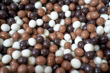 Zengin çikolata kaplı ısırıklar, yakın çekim kahverengi ve beyaz karışımı, gurme düşkünlüğü ve rahat kafeterya havası.,