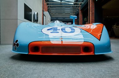 Aerodinamik giriş ve giysi grafikleri olan mavi ve turuncu yarış Porsche burnu, Varşova, Polonya 'yı 24-06-2025