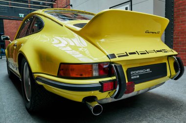 Sarı Porsche arka performans detaylarıyla egzoz, ördek kuyruğu ve rozet görünür, parlak metal Varşova, Polonya 24-06-2025