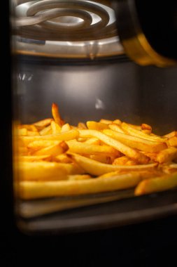 Kızarmış patates kızartması kızartması. Kızartma odasında parlayan sıcak patates kızartması. Altın tonlu uzun süreli atıştırmalıklar.