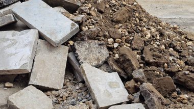 Kırık beton bloklar ve yıkım alanındaki taş molozlar pürüzlü dokuları ve parçalanmış şekilleri gösteriyor. Yapım, yıkım veya geri dönüşüm temaları için ideal. 