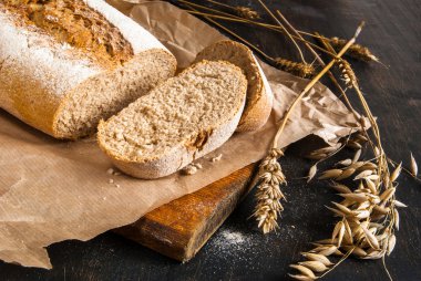Güzel kokulu taze pişmiş çavdar ekmeği bir siyah ahşap tablo
