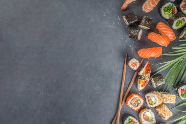 Çubuklu suşi. Çeşitli lezzetli Japon suşileri, yuvarlanan parçalar ve açık mavi arka planda nigiri.