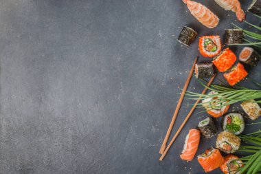 Çubuklu suşi. Çeşitli lezzetli Japon suşileri, yuvarlanan parçalar ve açık mavi arka planda nigiri.