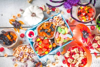 Cadılar Bayramı şekerleri ve şekerleri. Çeşitli çocuklar Cadılar Bayramı için şeker, kahvaltılık gevrek, şeker, yemek kutusu ve kova, düz fotokopi alanı üst görünümü.