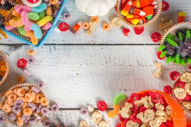 Cadılar Bayramı şekerleri ve şekerleri. Çeşitli çocuklar Cadılar Bayramı için şeker, kahvaltılık gevrek, şeker, yemek kutusu ve kova, düz fotokopi alanı üst görünümü.