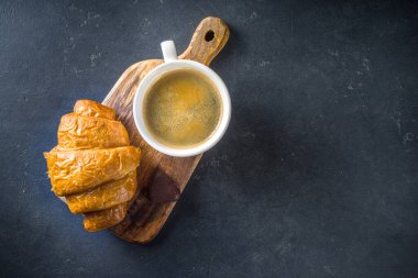  Kahve ve kruvasan. Günaydın ve Kahvaltı konsepti, metin alanı için fotokopi alanının üstündeki siyah beton arka plan