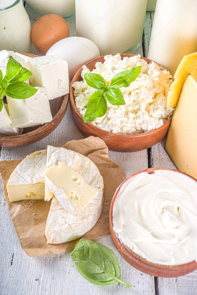 Set of Various Fresh Dairy Products - milk, cottage cheese, cheese, eggs, yogurt, sour cream, butter on wooden background