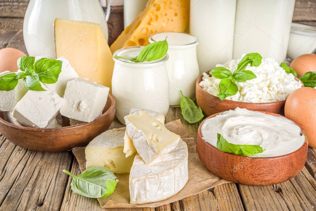 Set of Various Fresh Dairy Products - milk, cottage cheese, cheese, eggs, yogurt, sour cream, butter on wooden background