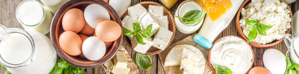 Set of Various Fresh Dairy Products - milk, cottage cheese, cheese, eggs, yogurt, sour cream, butter on wooden background