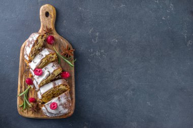  Noel şekeri, badem ezmesi ve kuru üzümle çalkalanıyor. Geleneksel Dresden İsa pastası. Köknar ağacı dalları ve Noel süslemeleri ile masa arkaplanda üst görünüm kopyalama alanı