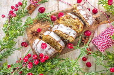  Noel şekeri, badem ezmesi ve kuru üzümle çalkalanıyor. Geleneksel Dresden İsa pastası. Köknar ağacı dalları ve Noel süslemeleri ile masa arkaplanda üst görünüm kopyalama alanı