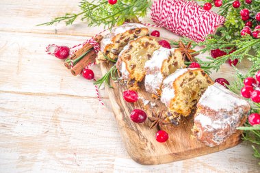  Noel şekeri, badem ezmesi ve kuru üzümle çalkalanıyor. Geleneksel Dresden İsa pastası. Köknar ağacı dalları ve Noel süslemeleri ile masa arkaplanda üst görünüm kopyalama alanı