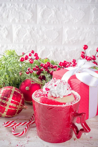 Candy cane peppermint mugcake. Simple Christmas breakfast, snack idea recipe, white and red swirled sponge cake in festive mugs with whipped cream and candy cane pieces topping