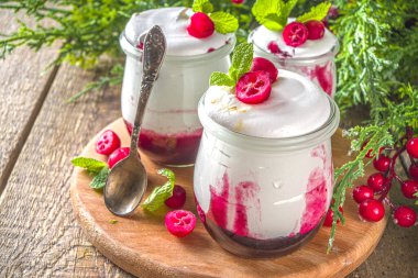 Noel sabahı için küçük kavanozlarda yaban mersini katmanlı tatlı kahvaltısı. Ev yapımı kızılcık kremalı tatlı, taze kızılcık ve naneli, kopyalama alanı.