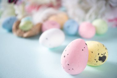 Paskalya tebrik kartı arkaplanında yumurta, çiçek ve kelebekler var.