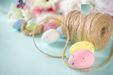 Paskalya tebrik kartı arkaplanında yumurta, çiçek ve kelebekler var.