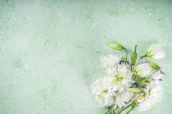 Springtime holidays background. Bouquet of garden  spring flowers on pastel green table top view. Greeting card for International Women Day, Mother Day etc. Flat lay.