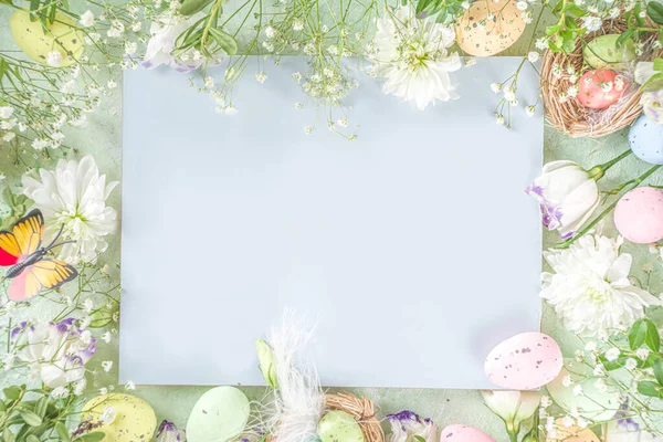 Happy Easter concept. Spring Easter holiday top view  flat lay background with easter eggs in nests and spring flowers. Easter greeting card background with copy space.