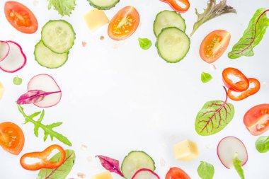 Bahar salatası malzemeleri konsepti. Beyaz arka planda sağlıklı yiyecekler. Sebze, domates, biber, yeşil yapraklar. Düz konum, üst görünüm, kopyalama alanı 