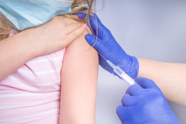 Coronavirus aşısı konsepti, covid-19 aşısı, Kafkasyalı küçük bir kızın koluna doktor aşısı, sağlıklı ve tıbbi konsept.