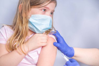 Coronavirus aşısı konsepti, covid-19 aşısı, Kafkasyalı küçük bir kızın koluna doktor aşısı, sağlıklı ve tıbbi konsept.