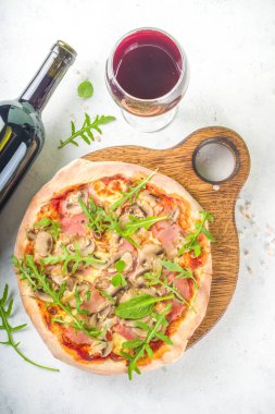 Pizza partisi konsepti. Farklı dolgulu pizzalar, farklı pizza parçaları, bardak ve şaraplı şişe. Beyaz arkaplanda düz görünüm kopyalama alanı