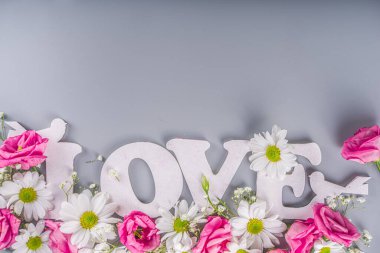 Sevgililer günü, anneler günü geçmişi, mavi arka planda çiçekli seni seviyorum yazısı. 