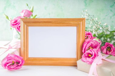 Beyaz ahşap arka planda güzel bahar çiçekleri. El işi kağıt hediye kutularıyla süslü çiçek kompozisyonu. Sevgililer günü, kadınlar günü, anneler günü tebrik kartı. Üst görünüm düzlüğü