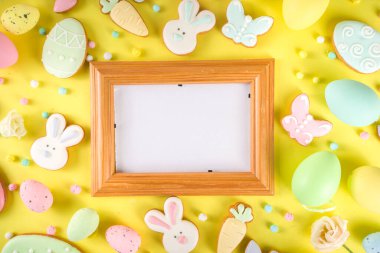 Paskalya kurabiyesi geçmişi. Renkli şekerli paskalya kurabiyeleri, Mutlu Paskalyalar ve çeşitli paskalya sembolleri ve dekorlarla birlikte. Geleneksel Paskalya tatlıları flaltay arka planı