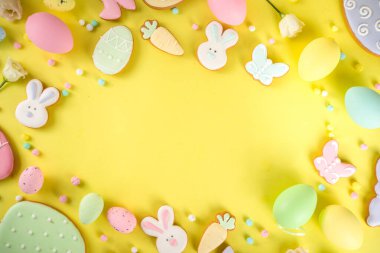 Paskalya kurabiyesi geçmişi. Renkli şekerli paskalya kurabiyeleri, Mutlu Paskalyalar ve çeşitli paskalya sembolleri ve dekorlarla birlikte. Geleneksel Paskalya tatlıları flaltay arka planı