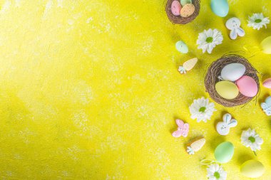Sarı arka planda Paskalya yumurtaları olan paskalya posterleri. Kutlama kartı, Paskalya Günü için hediyeler üst uzay fotokopisi