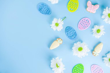 Paskalya posterinin arka planında açık mavi arka plandaki yuvalarda paskalya yumurtaları var. Kutlama kartı, Paskalya Günü için hediyeler üst uzay fotokopisi
