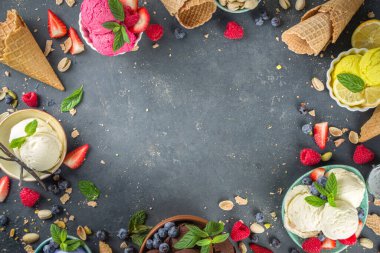 Farklı kaselerde çeşitli renkli dondurma topları, dondurma külahları ve aromalı malzemeler - şam fıstığı, böğürtlen, limon, çikolata, vanilya fasulyesi, nane. Koyu arkaplan kopyalama alanı